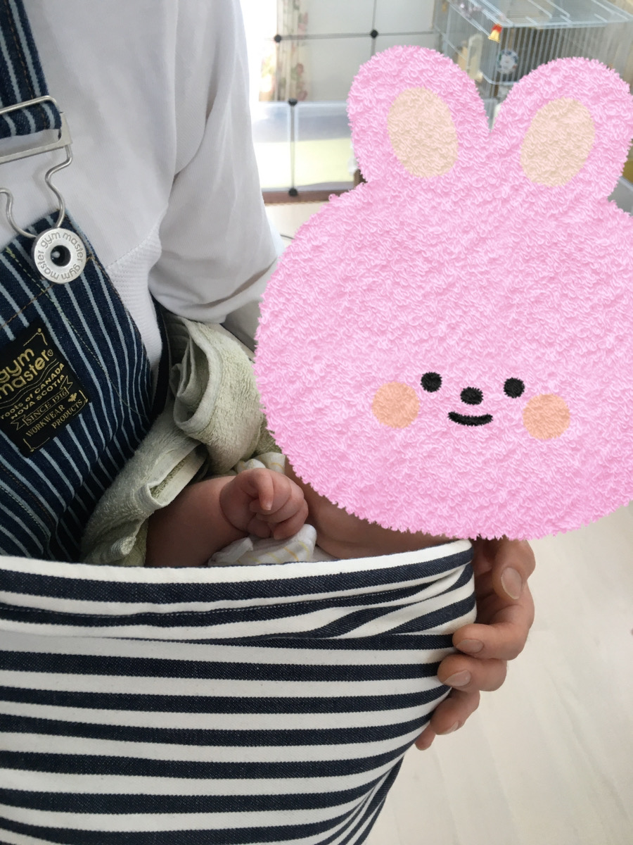 スリングの中にバスタオルを折りたたんで敷き、赤ちゃんを抱いている様子